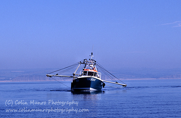 Scallop dredger heeling over as the dredges on one side catch fast on the seabed. Lyme Bay. Colin Munro Photography.