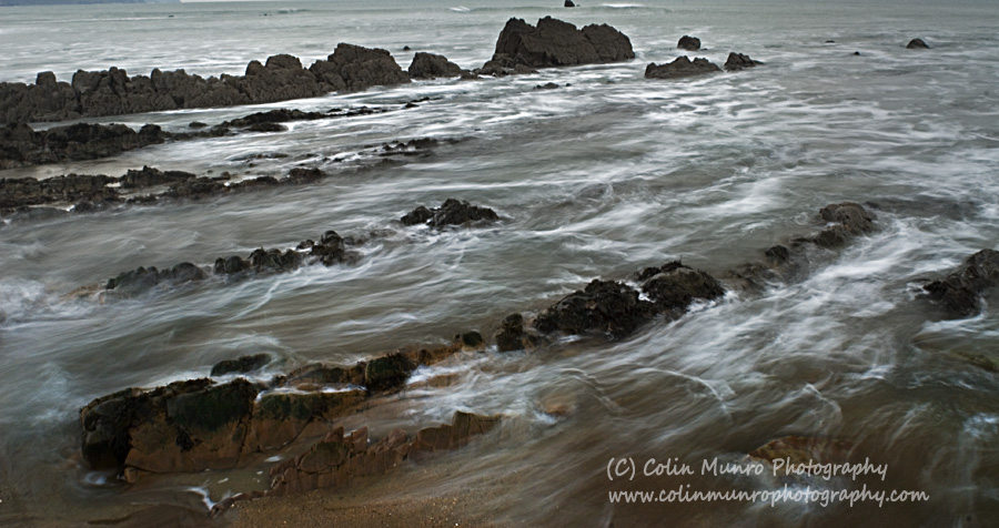 Waves spill over rocks, Widemouth Bay, North Cornwall. Colin Munro Photography
