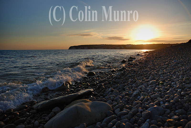 By creating shadows and so releif, the low lighting that occurs during the Golden Hour enhances the three dimensional appearance of features such as pebble beaches.  Sunset, Axmouth pebble beach, beneath Haven Cliff. 